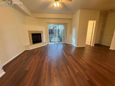 Unfurnished living room with a tile fireplace, dark wood-type flooring, and ceiling fan