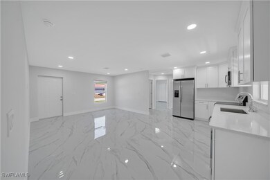 Kitchen with light countertops, a sink, stainless