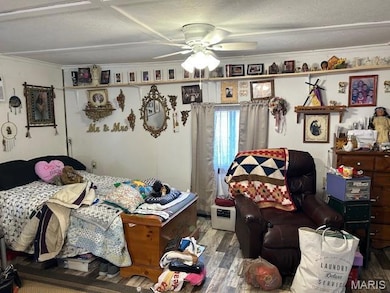 Bedroom featuring wood finished floors, a ceiling fan, and crown molding