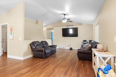 Living area featuring vaulted ceiling, wood finished floors, and ceiling fan