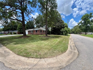 Single story home featuring brick siding and a front lawn