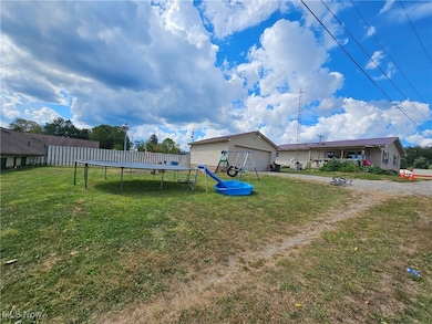 View of green lawn with a trampoline and a garage