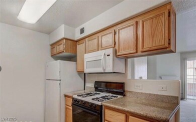 Kitchen featuring white appliances, carpet floors,