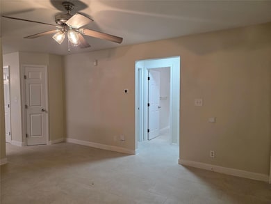 Unfurnished room with ceiling fan and baseboards