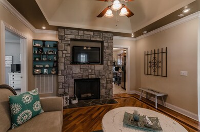 Living room with tray ceilings, recessed lighting, and sparkling hardwood floors (Photo from previous listing with permission).