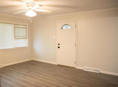 Foyer entrance with ceiling fan, crown molding, a textured ceiling, and dark hardwood / wood-style flooring