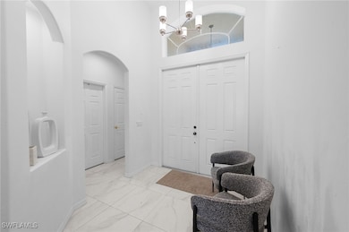 Entryway with light marble finish flooring, arched