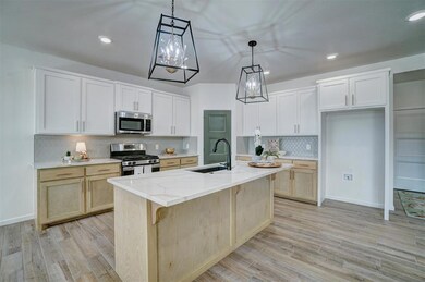 Kitchen with light stone countertops, backsplash, 