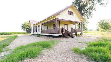 Back of house with covered porch and a metal roof