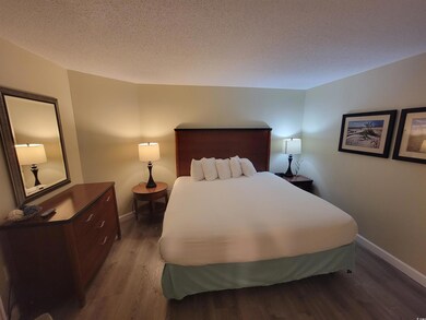 Bedroom with wood finished floors and a textured ceiling