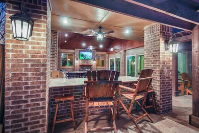 An outdoor oasis.  Amazing extra patio for entertaining .Bar seating with wood stained ceiling planks and beams.