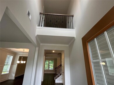 Stairway featuring ornamental molding, a chandelier, a high ceiling, and wood finished floors