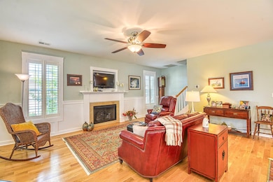 Living room featuring a ceiling fan, visible vents
