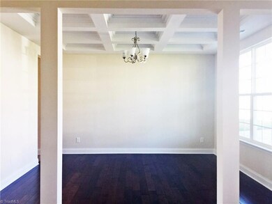 Formal dining room with  offered ceiling and hardwoods