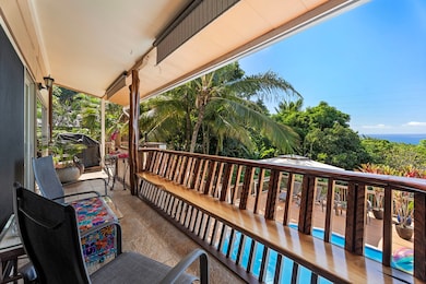 Wide lanai with custom carved banister overlooking the pool and gorgeous ocean view.