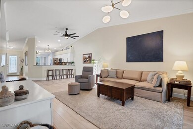 Living room featuring crown molding, light wood-style floors, ceiling fan, vaulted ceiling, and baseboards