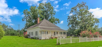 Rear view of house featuring covered porch and a l