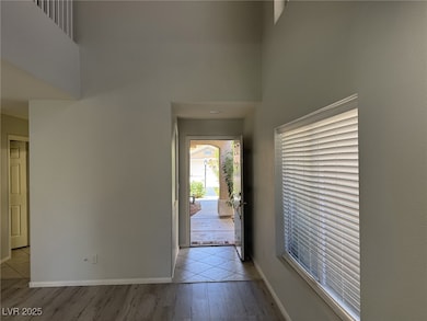 Foyer with a towering ceiling, light wood-style fl
