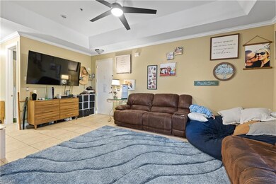 Tiled living room with ceiling fan, a tray ceiling