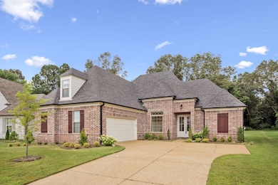 View of front of property with brick siding, an attached garage, driveway, a shingled roof, and a front lawn