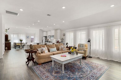 Oversized family room with a wall of windows and privacy drapes bringing in tons of natural light.
