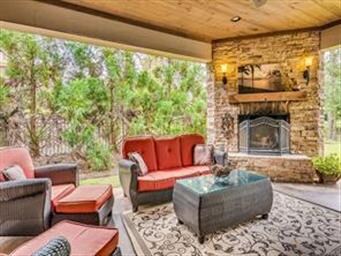 Covered porch with an outdoor fireplace views to t