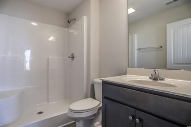 Bathroom with toilet, walk in shower, and vanity