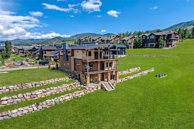 Back of house with a balcony, a lawn, a mountain v