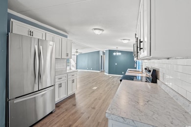 Kitchen featuring ornamental molding, white cabine