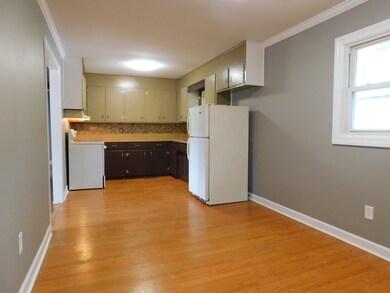 The eat-in kitchen has a laminate wood floor and a tile back splash. 