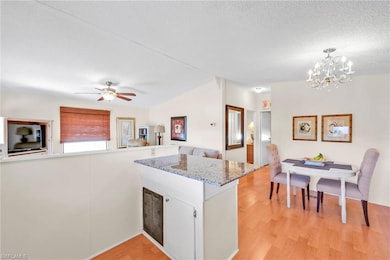Kitchen with light wood finished floors, visible vents, open floor plan, a peninsula, and a textured ceiling