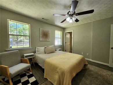 Bedroom with baseboards, wood finish floors, a tex