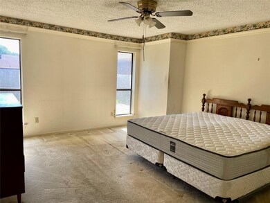 Bedroom with ceiling fan, a textured ceiling, and 