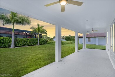 Patio terrace at dusk with ceiling fan and a yard