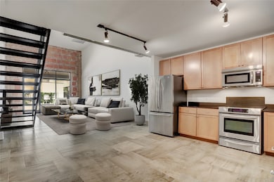 A view from the kitchen reveals the generous scale of the main living space, where the open-concept layout creates a natural connection between dining, lounging, and entertaining areas. High ceilings and expansive walls enhance the airy atmosphere. This layout offers both functionality and style, ideal for everyday living or hosting guests with ease.  This photo is virtually staged.
