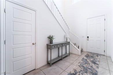 Foyer with stairs, light tile patterned floors, ba