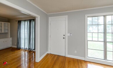 Foyer featuring ornamental molding and light hardw