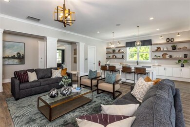 Living room with ornamental molding, wood-type flo