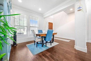 Dining room featuring ornamental molding, dark wo