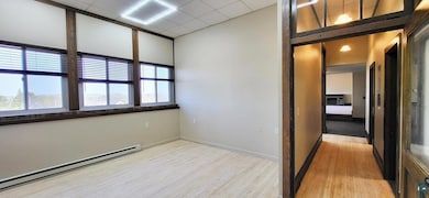 Empty room with baseboard heating and light wood finished floors