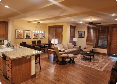 Living area with recessed lighting, dark wood finished floors, ceiling fan, and a chandelier