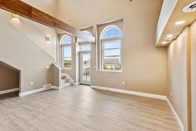 Entrance foyer with beamed ceiling, hardwood / wood-style floors, and a towering ceiling