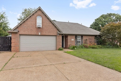 Traditional-style home with brick siding, a shingled roof, driveway, and a garage