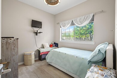 Bedroom with wood finished floors and baseboards