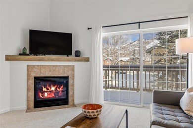 Carpeted living room with a tile fireplace