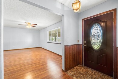 Foyer entrance featuring ceiling fan, a textured c