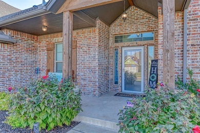 Doorway to property featuring covered porch, brick siding, and a shingled roof