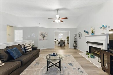 Living room with a high end fireplace, vaulted cei