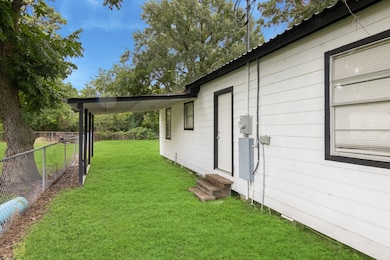 On the side of the home is a nicely sized car port wit access directly into the home. The yard is fenced with trees in the background providing shade and privacy.