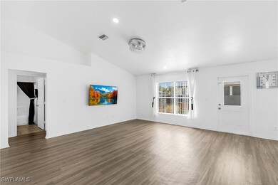 Unfurnished living room with vaulted ceiling, wood